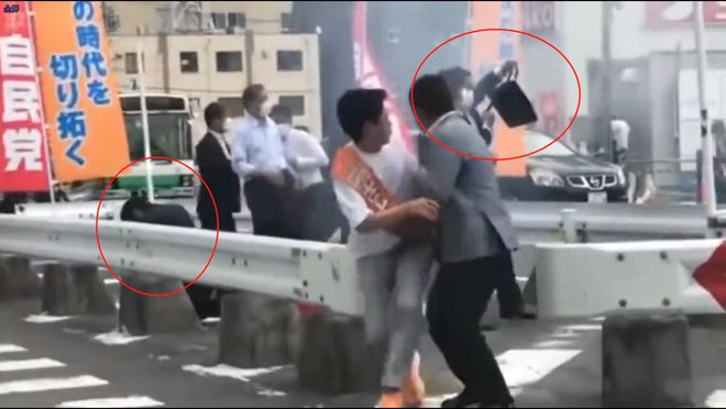 安倍后方仅有一名同样手持防弹公文包的特警试图挡住嫌疑人的第二枪